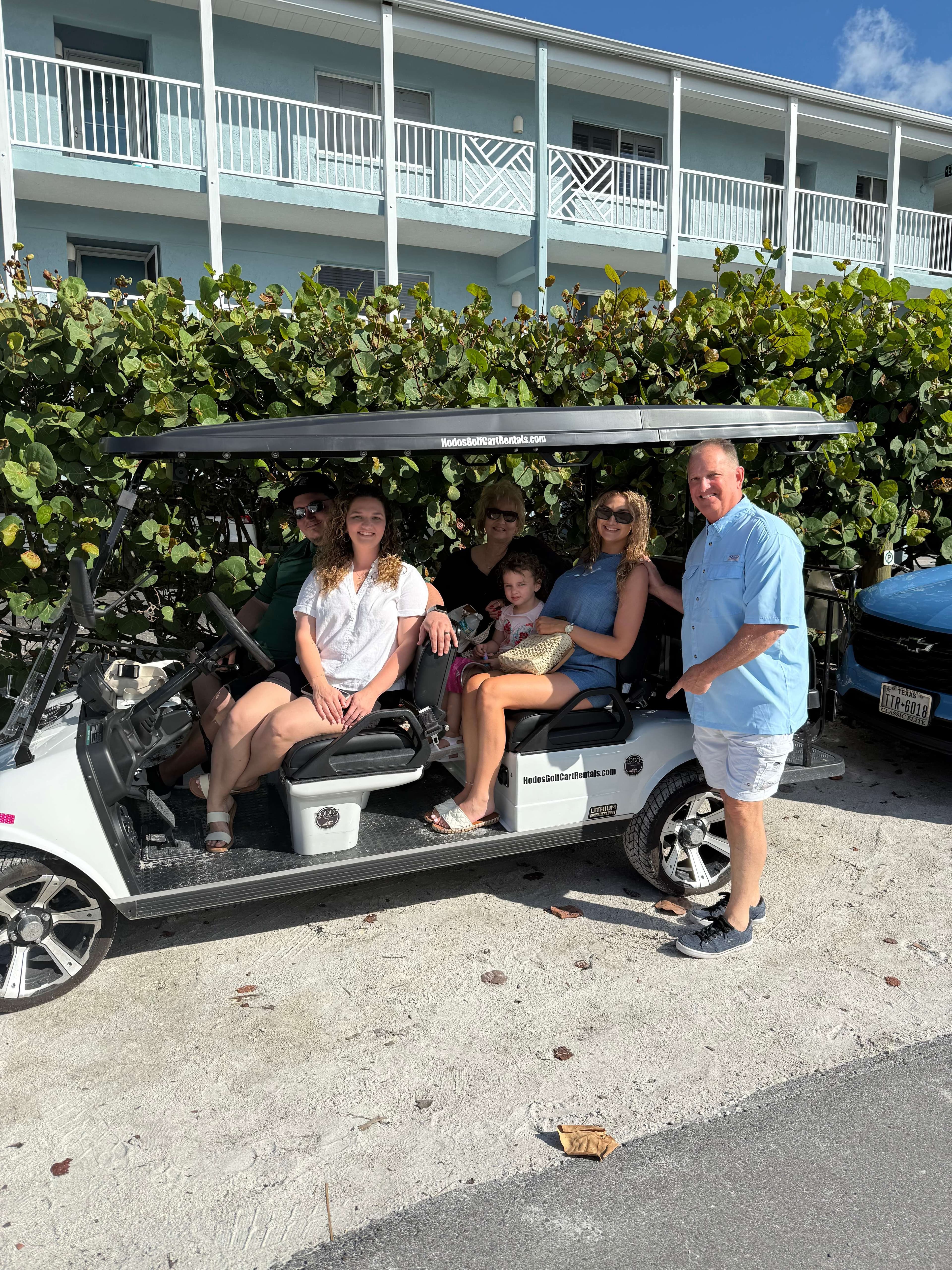A happy family of six enjoying their Hodo's golf cart rental on Anna Maria Island