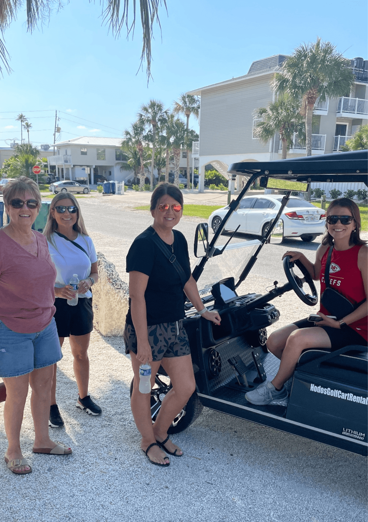 Group of women beside a black Hodo's golf cart